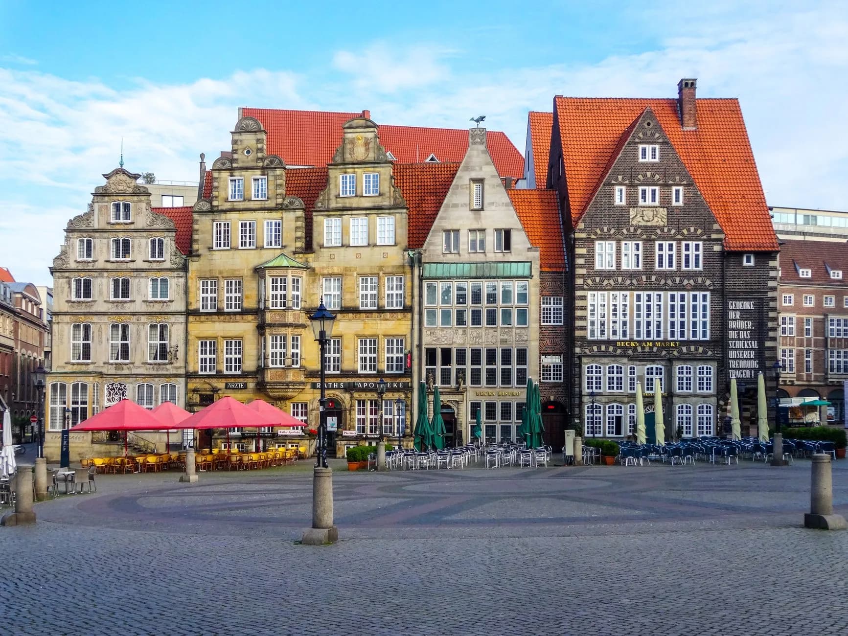 Historische Giebelhäuser mit roten Dächern am Marktplatz Bremen mit Cafés und Sonnenschirmen