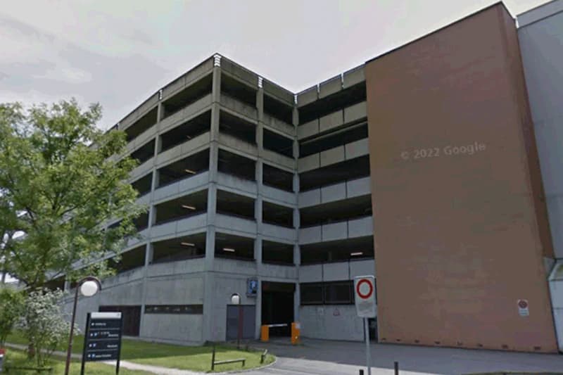 Mehrstöckiges Parkhaus mit offener Galerie und Einfahrt mit Schranke am Flughafen Frankfurt.