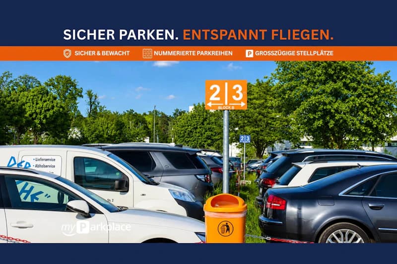 Dicht geparkte Autos auf einem Außenparkplatz mit orangefarbenem Reihenschild 2/3 und Mülleimer, Bäume im Hintergrund.