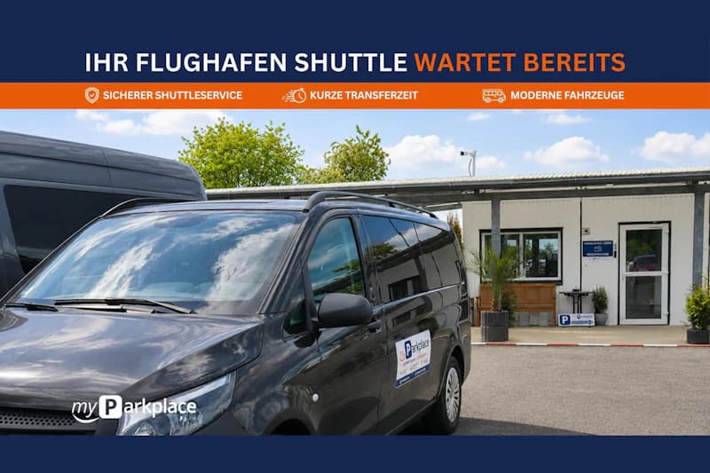 Schwarzer Kleinbus mit myParkplace-Aufkleber vor einem flachen Empfangsgebäude mit Vordach.