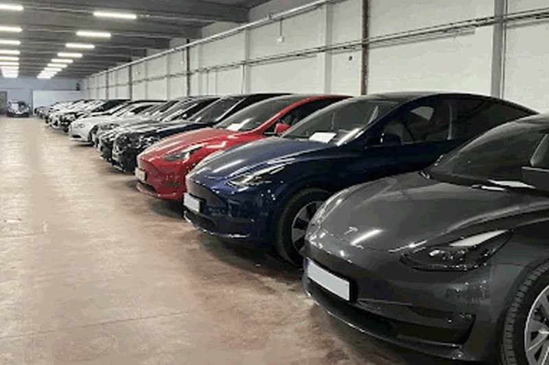 Mehrere geparkte Autos nebeneinander in einer hellen, überdachten Parkgarage.