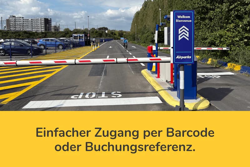 Schrankenauffahrt zu Parkfläche mit Stop-Markierung, blauem Willkommensschild Airparks und geparkten Autos.