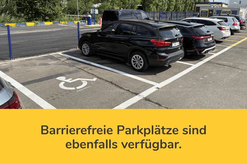 Außenparkplatz mit mehreren geparkten Autos und markiertem Behindertenparkfeld im Vordergrund sowie gelbem Hinweisband unten.