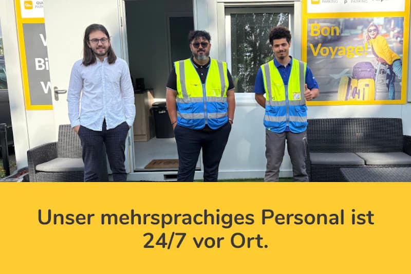 Drei Mitarbeiter vor einem weißen Bürocontainer, zwei tragen gelbe Warnwesten, Werbebanner mit Hinweis auf mehrsprachiges Personal sichtbar.