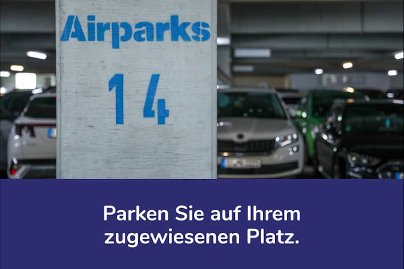 Stahlpfeiler mit Airparks-Logo und Zahl 14 in einem beleuchteten Parkhaus, geparkte Autos im Hintergrund.