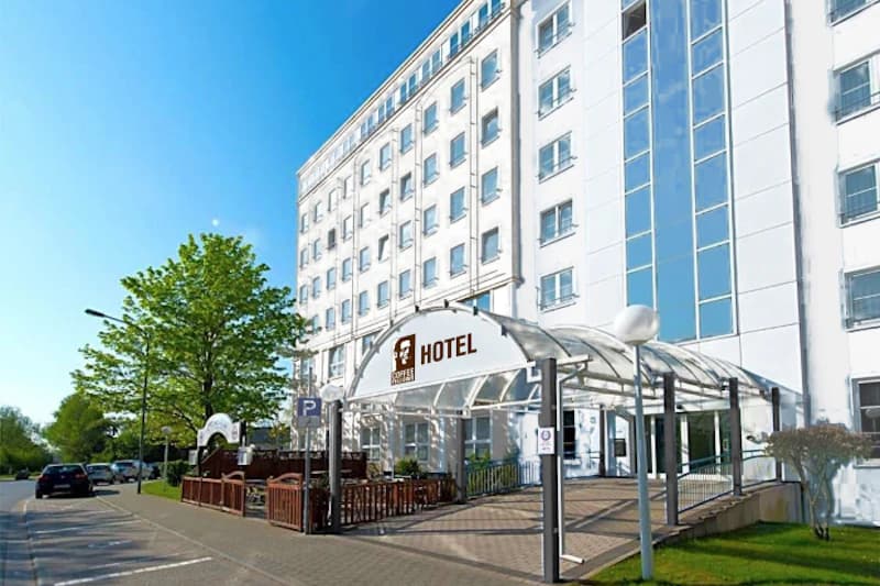 Weiße Hotelfassade mit überdachtem Eingangsbereich und Schild Coffee Fellows Hotel.