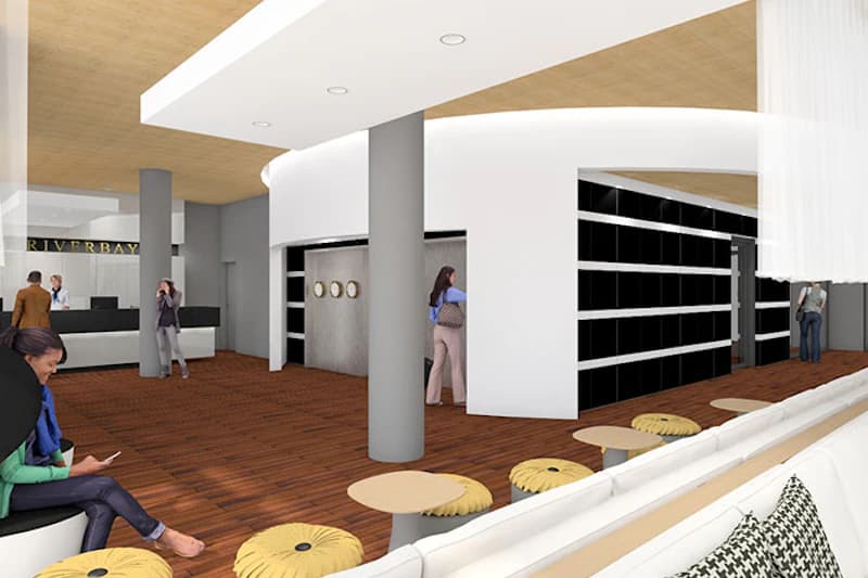 Moderne Hotellobby mit Sitzbank, runden Hockern, Tischen, hölzernem Boden, Säulen, Empfangstheke und Personen.