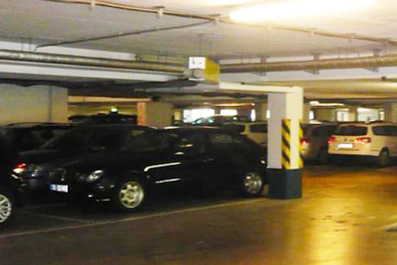 Tiefgaragenebene mit mehreren geparkten Pkw und sichtbaren Betonstützen.