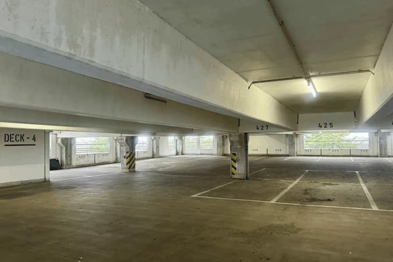 Leeres mehrstöckiges Parkdeck mit Betonstützen und markierten Stellplätzen, Beschriftung Deck -4 und Nummern 425/427.