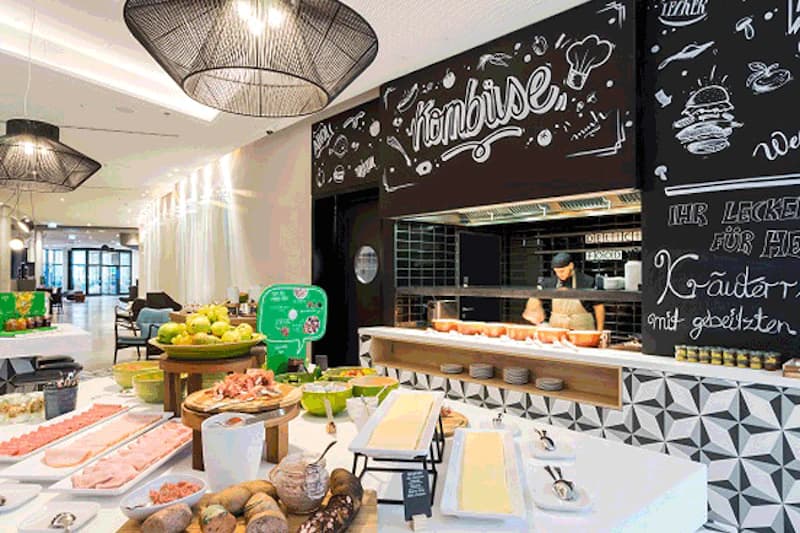 Frühstücksbuffet mit Aufschnitt, Brot, Obst und offener Küche mit Kombüse-Tafel.