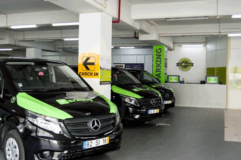 Schwarze Mercedes-Transporter mit grüner Easy Parking Beklebung in beleuchteter Parkhalle neben Säule mit gelbem Schild.
