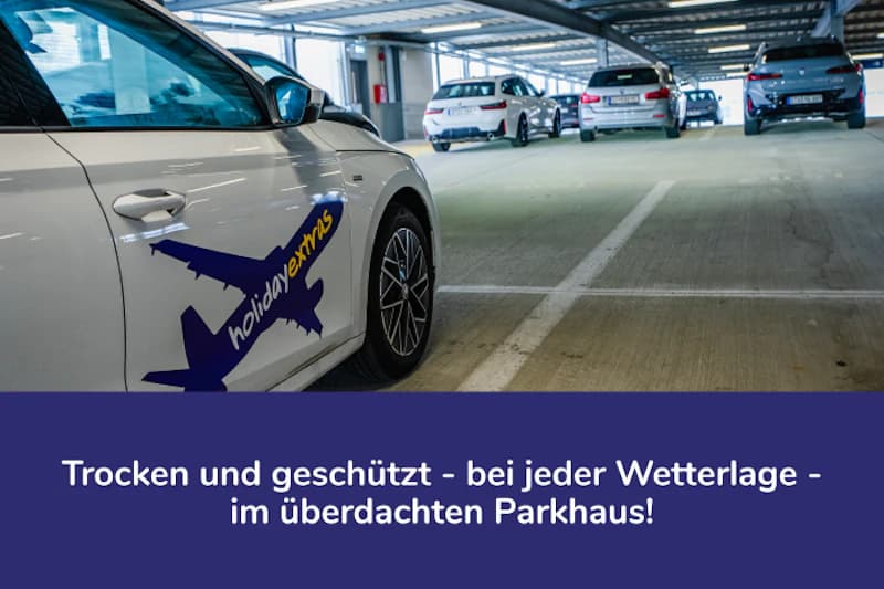 Überdachtes Parkhaus mit geparkten Autos, vorne ein weißes Auto mit holidayextras-Logo.