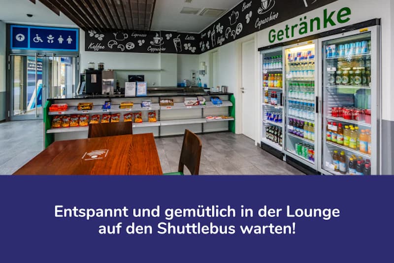 Lounge mit Tisch, Regalen mit Snacks, Getränkekühlschränken und Selbstbedienungstheke.