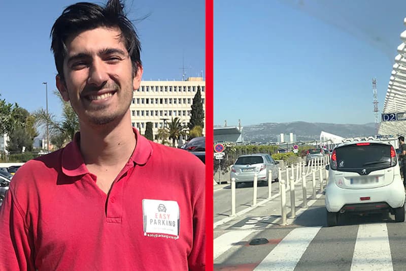 Mann in rotem Polo mit Easy Parking Schild links, rechts Fahrspur mit wartenden Autos vor Terminal am Flughafen.