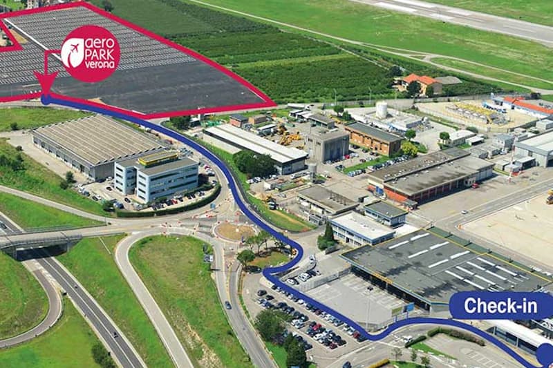 Luftaufnahme des Flughafengeländes von Verona mit markiertem Parkplatzbereich in Rot und blauem Fahrweg zum Check-in.